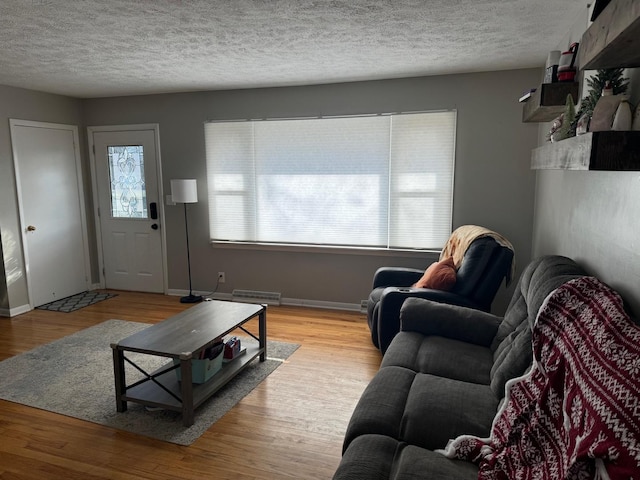 living room featuring a textured ceiling and light wood-type flooring