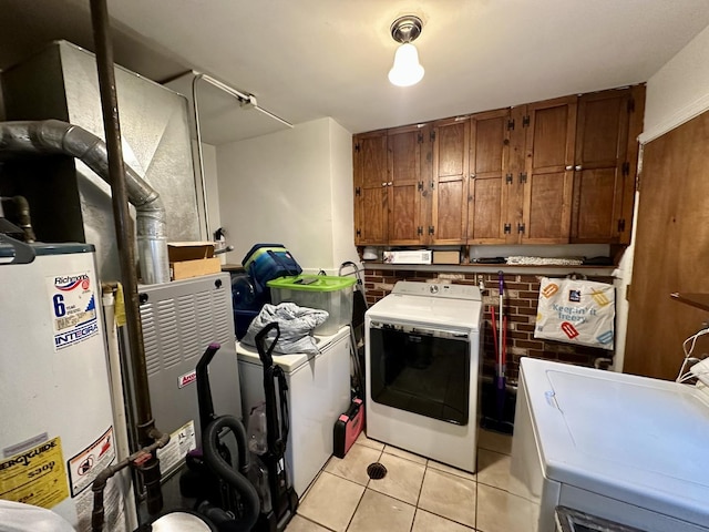 laundry room featuring light tile patterned floors, gas water heater, cabinets, and washing machine and clothes dryer