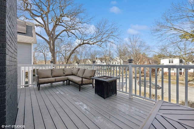 wooden terrace featuring an outdoor living space with a fire pit