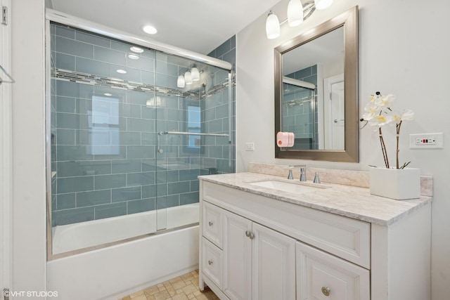 bathroom featuring vanity and shower / bath combination with glass door