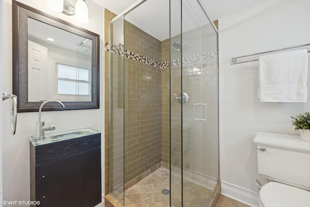 bathroom featuring vanity, a shower with shower door, and toilet