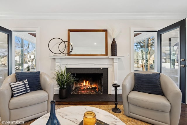 sitting room with hardwood / wood-style floors and ornamental molding