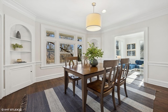 dining area with crown molding, dark hardwood / wood-style flooring, and built in features