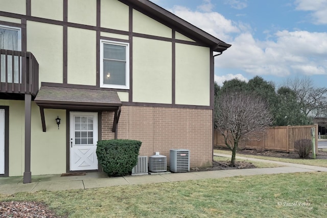 view of property exterior with central AC unit and a lawn