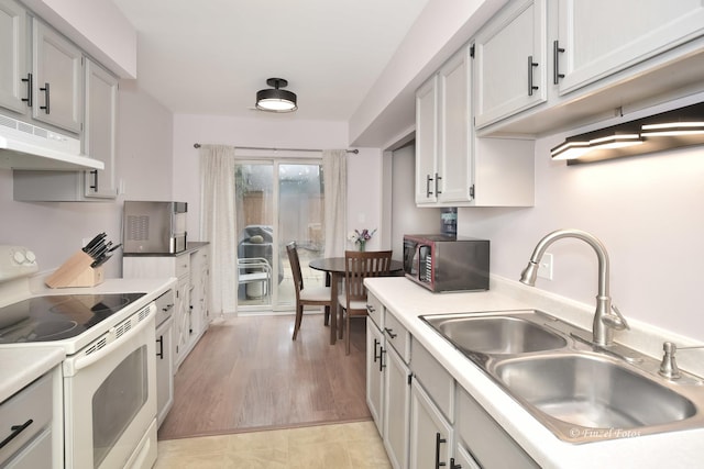 kitchen featuring white electric stove, sink, and light hardwood / wood-style floors