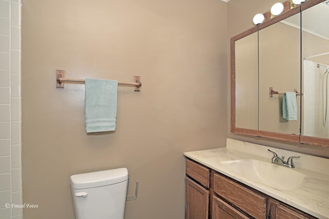 bathroom with walk in shower, vanity, and toilet