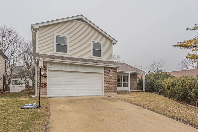 view of property with a garage and a front lawn