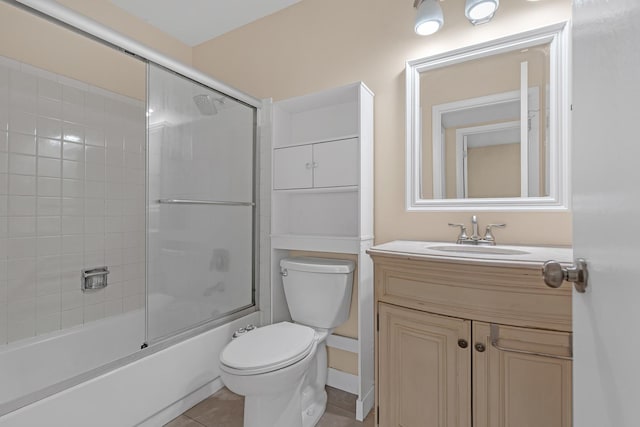 full bathroom with bath / shower combo with glass door, vanity, toilet, and tile patterned flooring