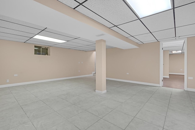 basement with light tile patterned flooring and a drop ceiling