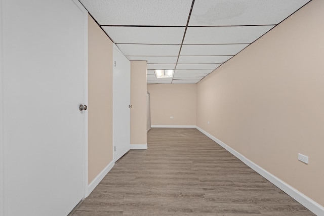 hall featuring a drop ceiling and light wood-type flooring