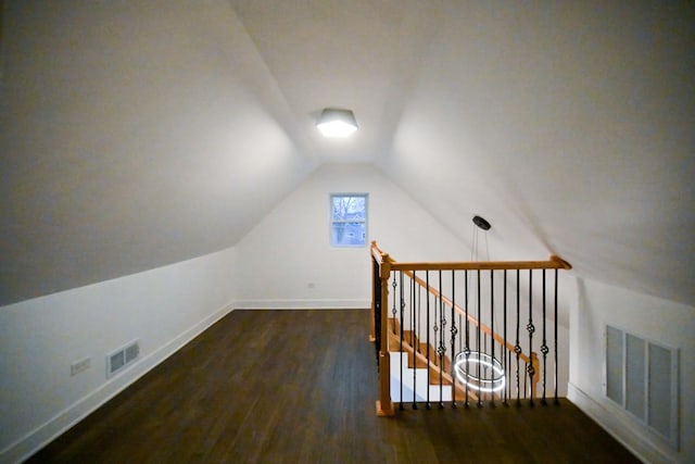 additional living space featuring dark wood-type flooring and vaulted ceiling