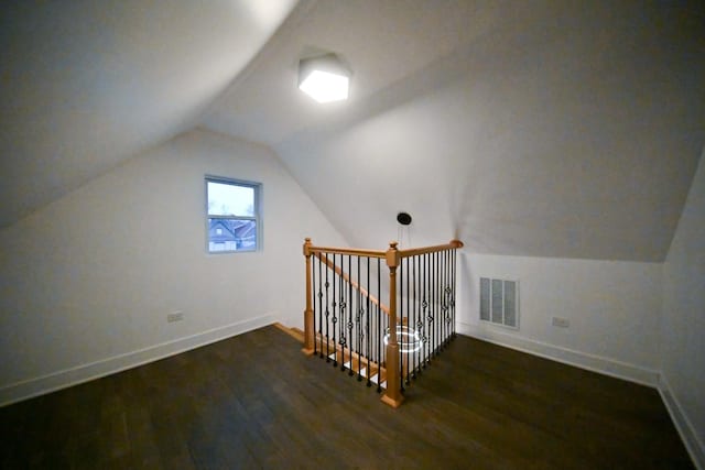 additional living space with vaulted ceiling and dark hardwood / wood-style floors