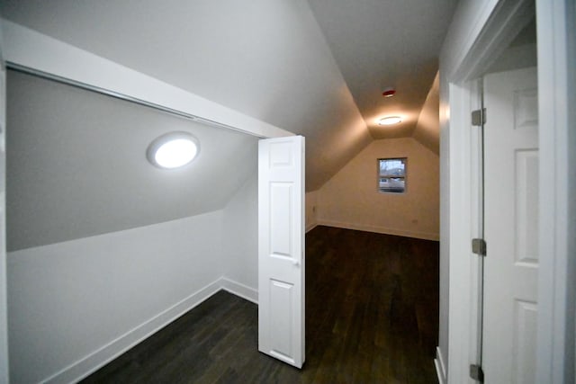 bonus room with dark hardwood / wood-style flooring and vaulted ceiling