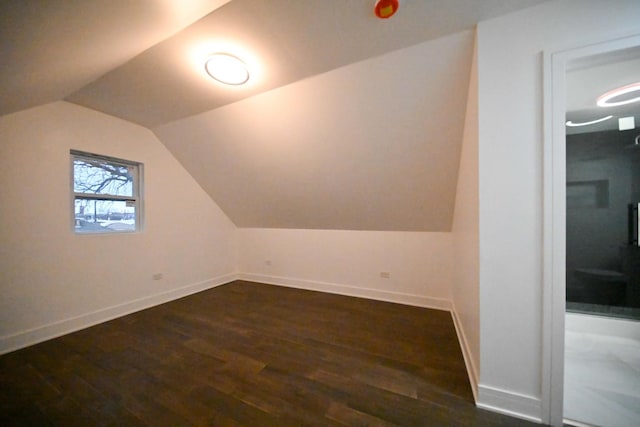 bonus room featuring lofted ceiling and dark hardwood / wood-style flooring