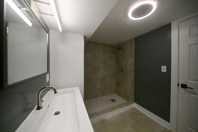 bathroom with tiled shower and sink