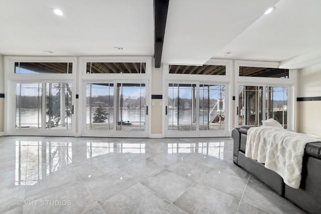 bedroom with multiple windows, access to outside, and beamed ceiling