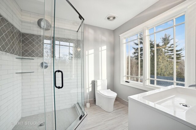 bathroom featuring walk in shower and toilet