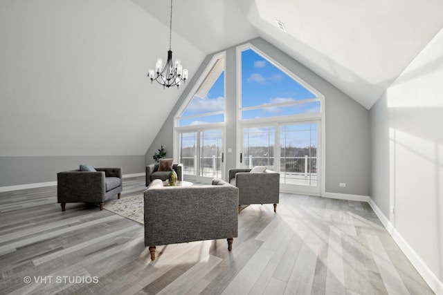 living room with lofted ceiling, hardwood / wood-style floors, and a chandelier