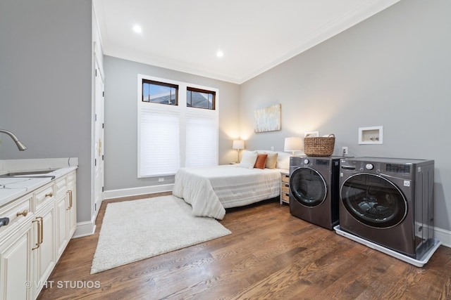 bedroom featuring crown molding, washing machine and clothes dryer, dark hardwood / wood-style floors, and sink