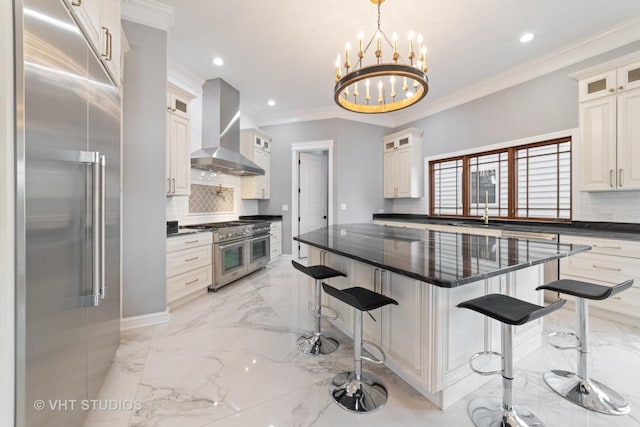 kitchen featuring a breakfast bar, decorative light fixtures, ventilation hood, high end appliances, and a center island