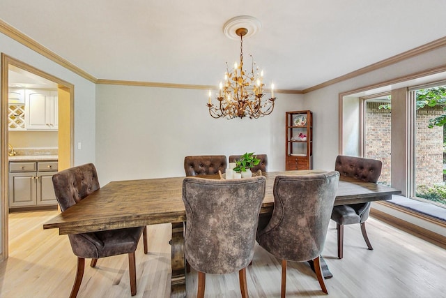 dining space with ornamental molding, light hardwood / wood-style flooring, and a notable chandelier