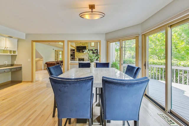 dining area with a fireplace and light wood-type flooring