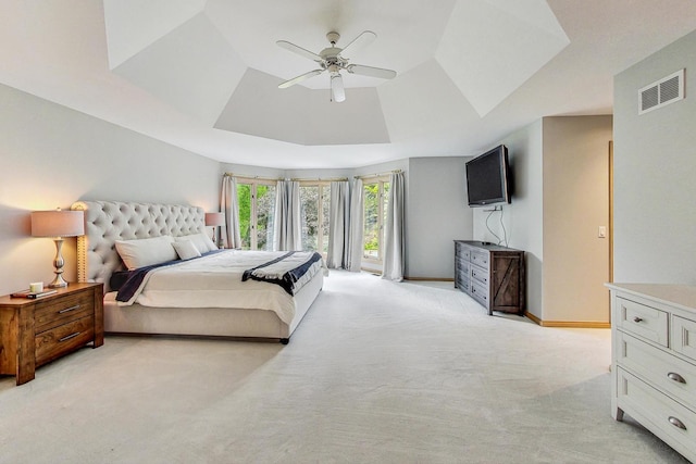 carpeted bedroom with ceiling fan and a tray ceiling