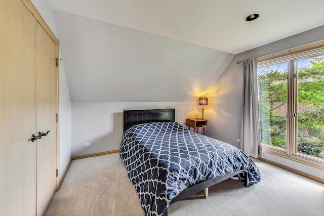 bedroom with lofted ceiling and light colored carpet