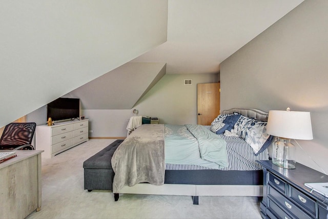 bedroom with vaulted ceiling and light carpet