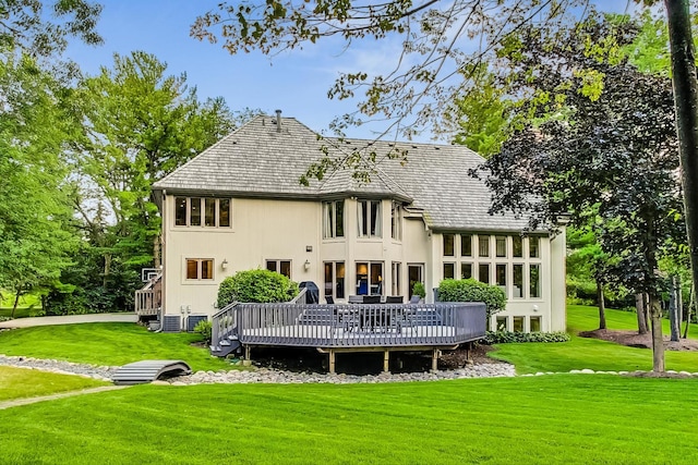 rear view of property featuring a wooden deck and a yard