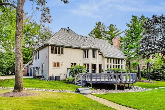 back of property featuring central AC unit, a yard, and a deck