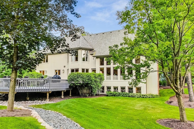 rear view of house with a wooden deck and a yard