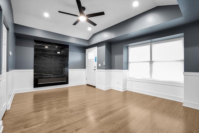 interior space featuring lofted ceiling, hardwood / wood-style flooring, a tile fireplace, and ceiling fan