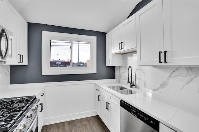 kitchen with dark wood-type flooring, sink, tasteful backsplash, stainless steel appliances, and white cabinets