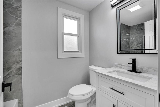 bathroom featuring vanity, toilet, and a tile shower