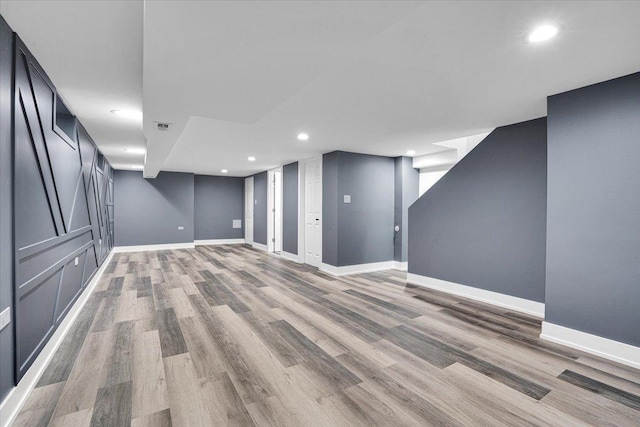 basement with light hardwood / wood-style floors