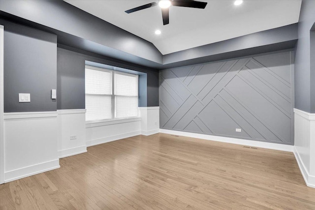 empty room with light hardwood / wood-style flooring, ceiling fan, and vaulted ceiling