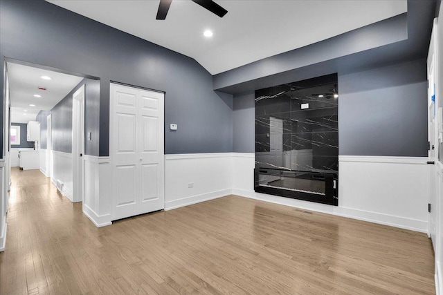 spare room with lofted ceiling, ceiling fan, and light hardwood / wood-style flooring