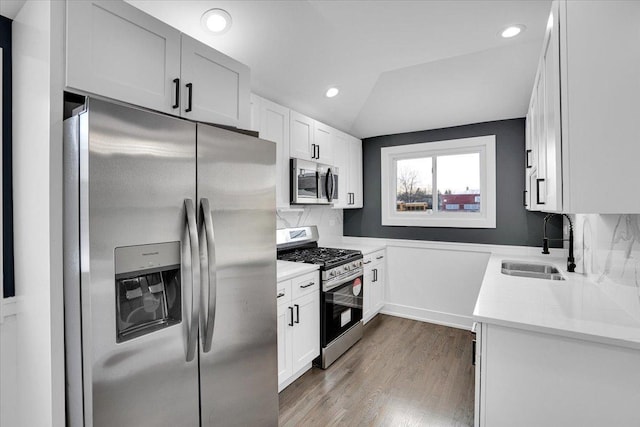 kitchen featuring light stone countertops, decorative backsplash, stainless steel appliances, and white cabinets