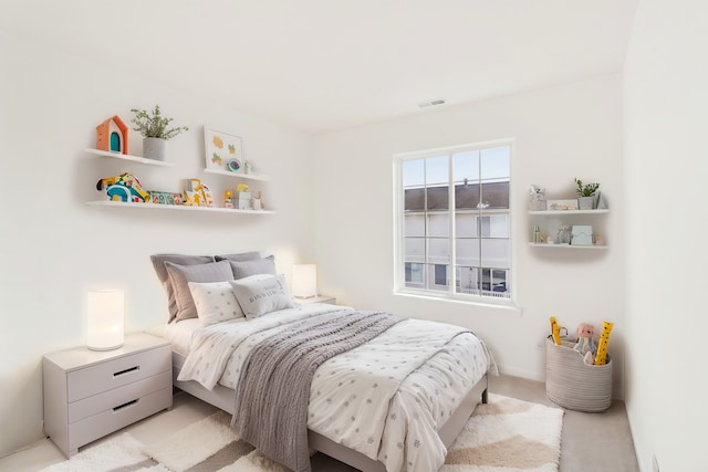 bedroom featuring visible vents and light carpet