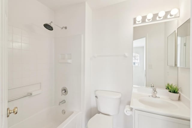 bathroom featuring  shower combination, vanity, and toilet