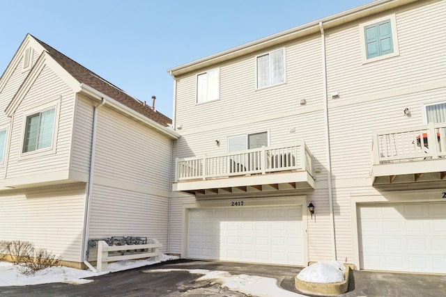 back of property with a garage and a balcony