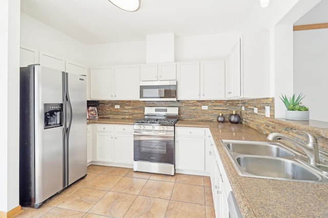 kitchen with stainless steel appliances, a sink, white cabinetry, light countertops, and backsplash