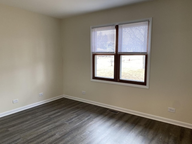 spare room with dark wood-type flooring