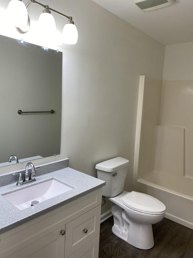 full bathroom featuring vanity, toilet, bathing tub / shower combination, and hardwood / wood-style floors