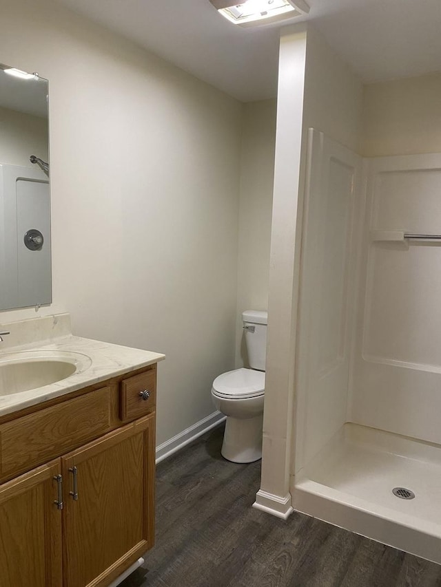 bathroom with vanity, wood-type flooring, a shower, and toilet