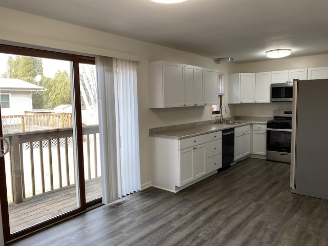 kitchen with dark hardwood / wood-style flooring, sink, white cabinets, and appliances with stainless steel finishes