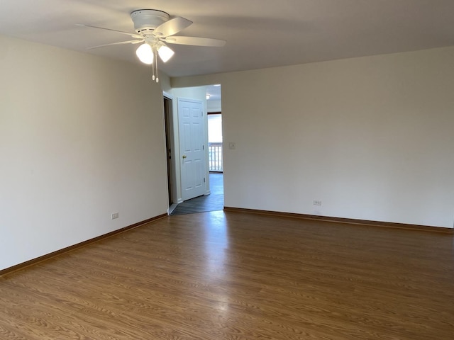 empty room with dark hardwood / wood-style floors and ceiling fan