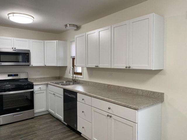 kitchen with white cabinetry, appliances with stainless steel finishes, dark hardwood / wood-style flooring, and sink