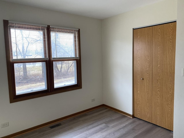 unfurnished bedroom featuring light hardwood / wood-style floors and a closet